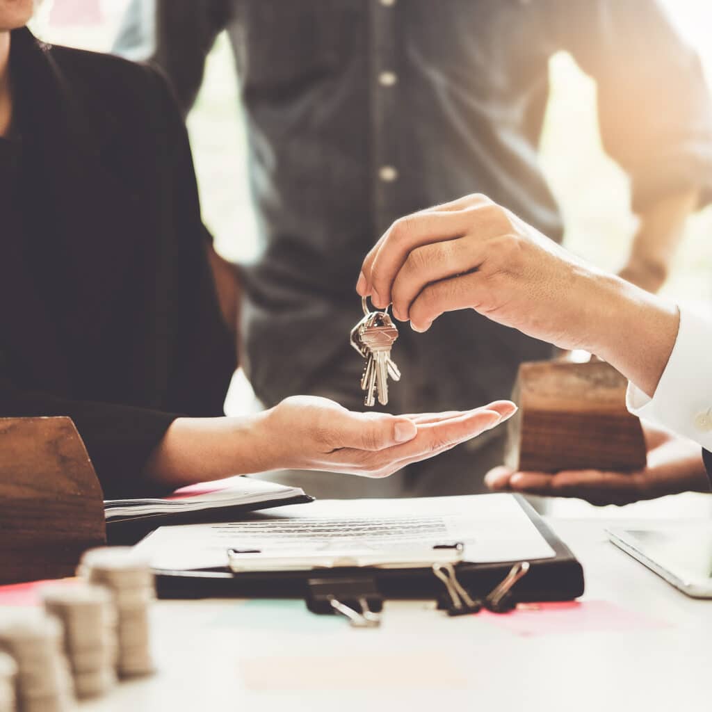 Remise des clés : Clôture transaction immobilière et achat maison Remise de clés de maison à un acheteur par un professionnel, symbolisant la conclusion réussie d'une transaction immobilière.